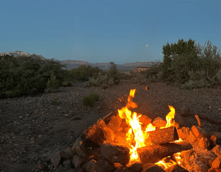 campfire at dusk with a scenic view of a desert landscape near utah and nevada, usa
